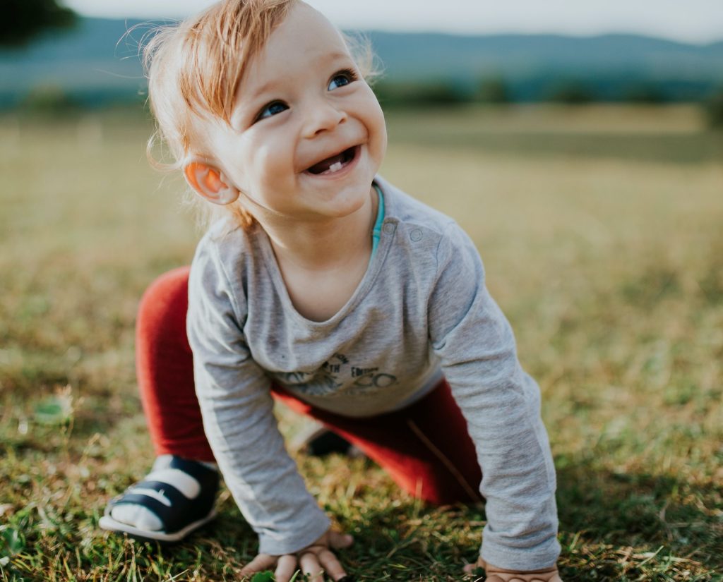 a toddler smiling with two bottom teeth showing